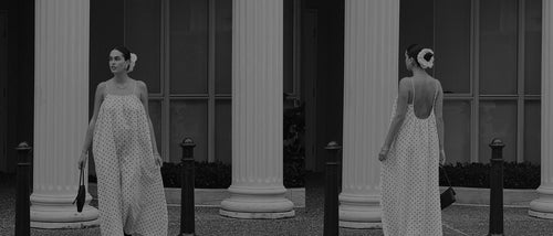 Woman in a LILLY PILLY Polka dot linen dress standing between two columns.