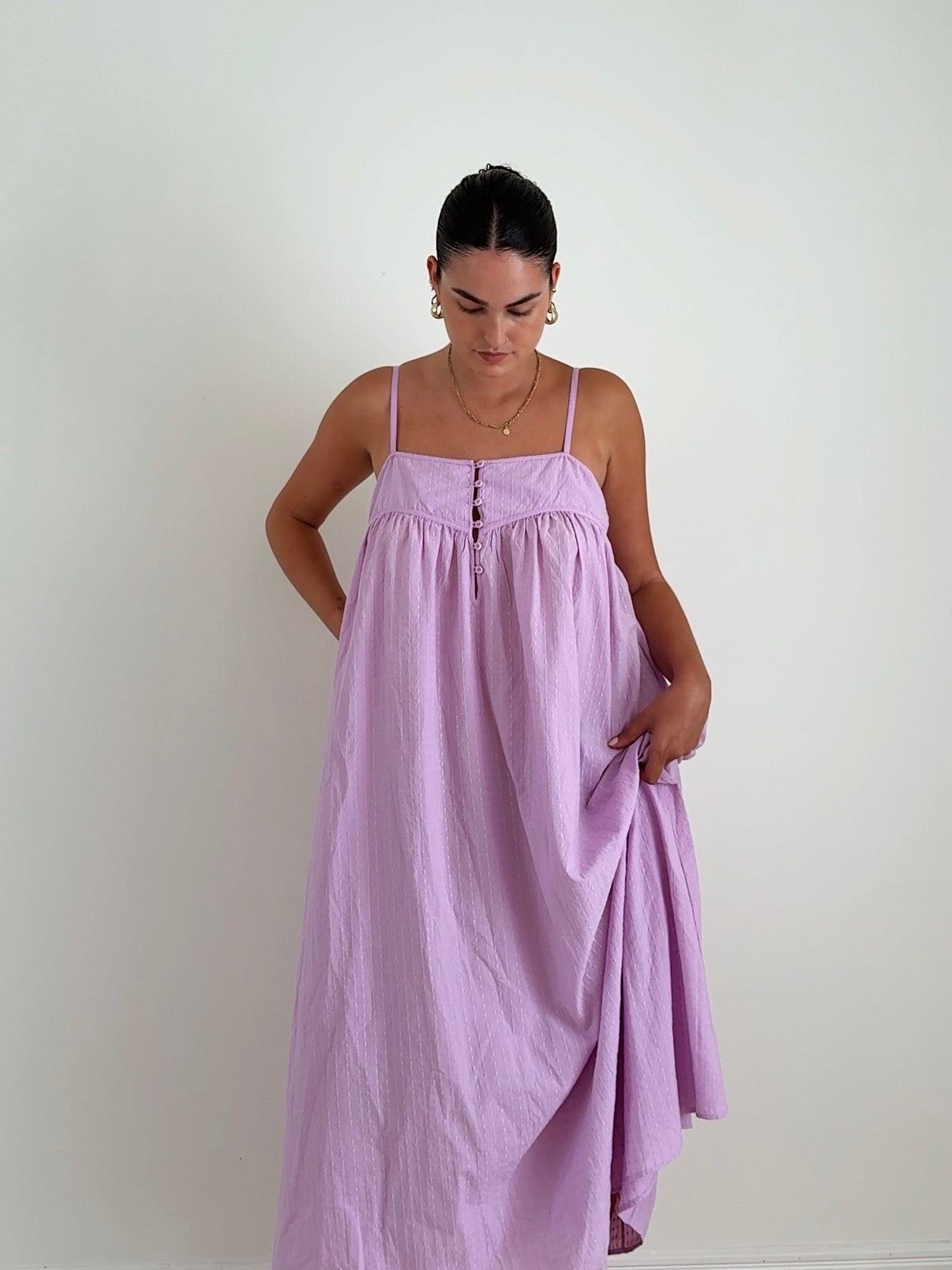 Woman wearing a light purple dress against a plain background