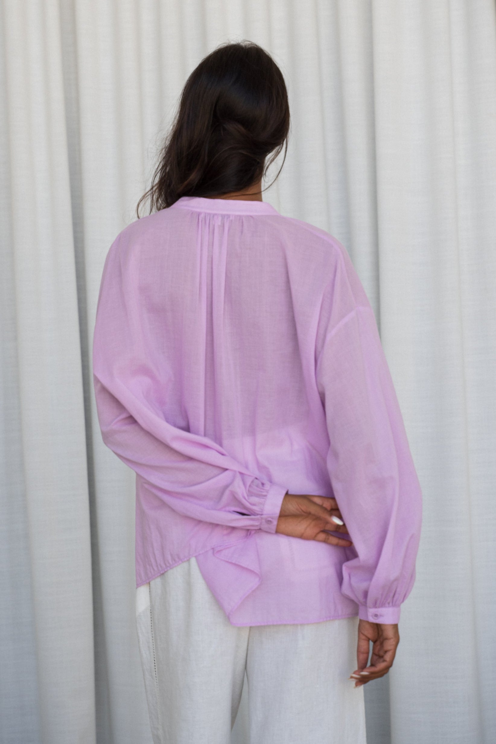 LILLY PILLY woman wearing a orchid Ember cotton voile shirt against a neutral background showing back view