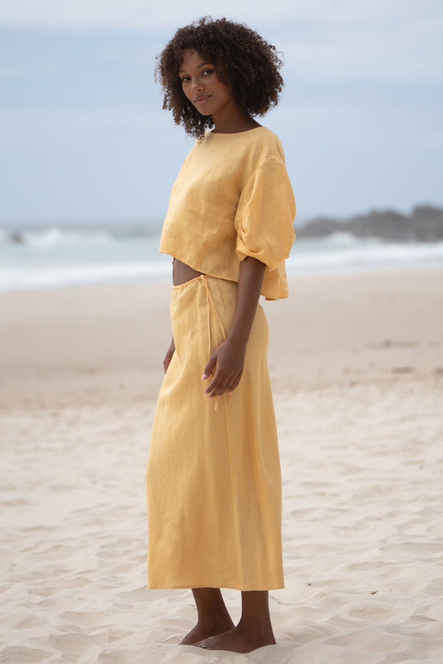 LILLY PILLY Leia linen top in Butter with Riley skirt showing full length view on beach