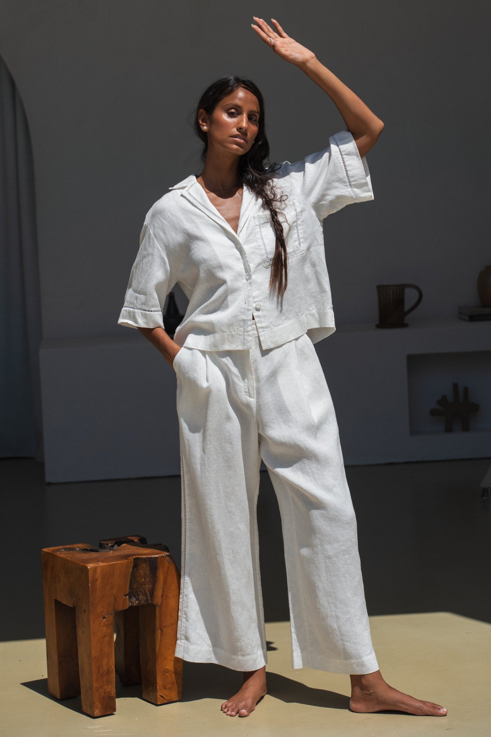 Woman in a ivory Rika linen pants and Quinn shirt standing in the sun