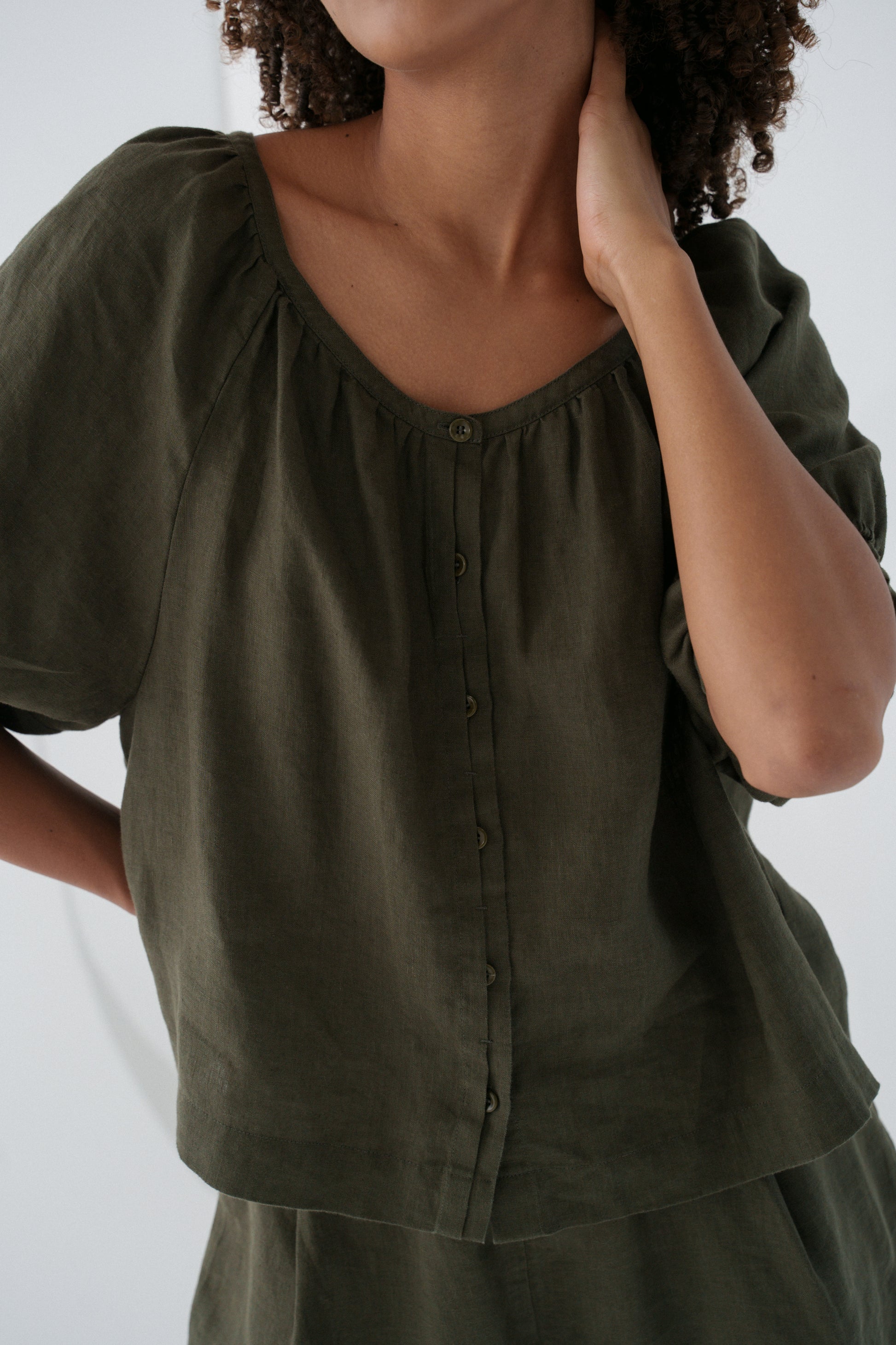 LILLY PILLY woman wearing a khaki Pia linen shirt top on a white background